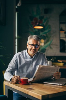 Cafe barda adam içme kahve ve gazete okuma