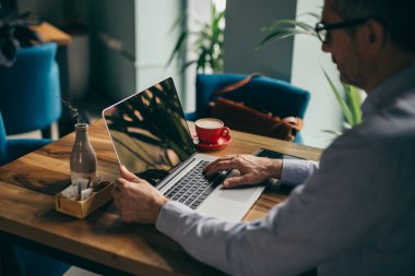 Cafe barda kahve molası üzerinde laptop kullanarak işadamı arka görünümü