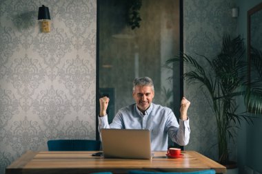 Cafe Bar laptop kullanarak mutlu gri saçlı adam