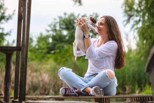 Женщина играет со своим щенком на открытом воздухе — стоковое фото
