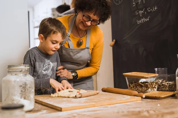 grandson and grandmother cooking together in home kitchen