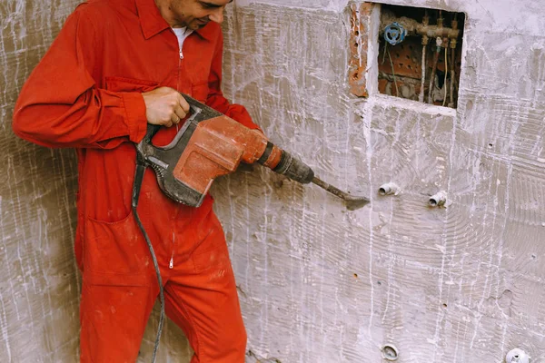 Handyman using drill machine to remove tiles