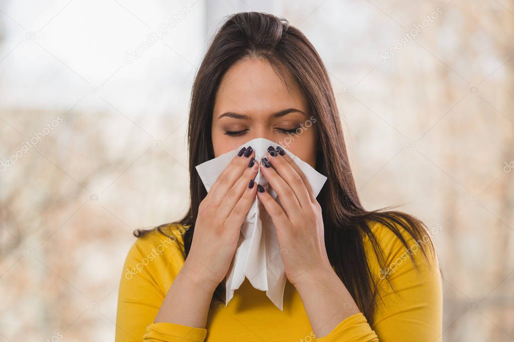 woman blowing nose with napkin