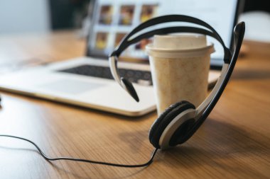 Kahve fincanı, müşteri destek konsepti ile masa da mikrofon ve dizüstü bilgisayar içeren kulaklıklar.