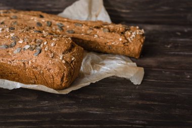 Krono ekmek somunna natürmort kopya alanı ile koyu ahşap arka plan üzerinde parşömen kağıt üzerinde servis