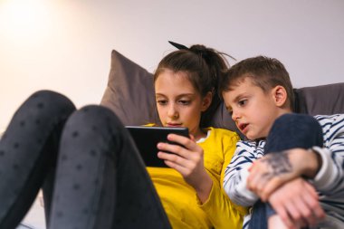 Küçük çocuklar - evde tablet kullanarak erkek ve kız kardeşi