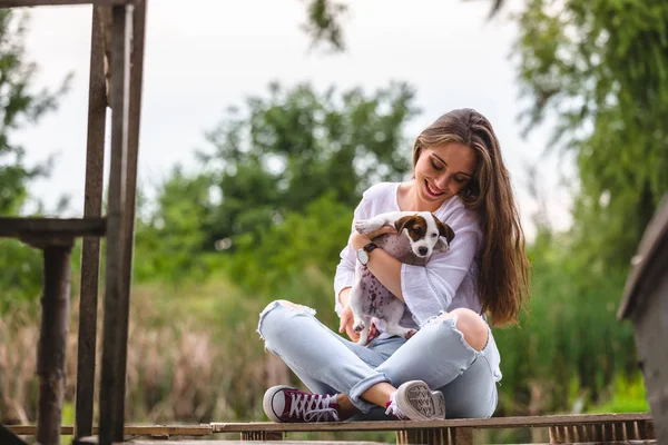 Kvinna leker med hennes valp utomhus — Stockfoto