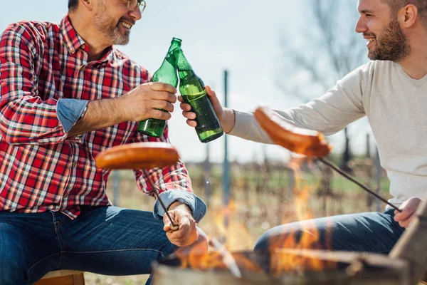 Festtid Utomhus Män Klinkande Flaskor Matlagning Korv Grillen — Stockfoto