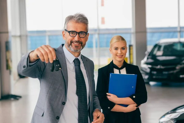 Man Holding Keys Car Dealership Showroom — Stock Photo, Image