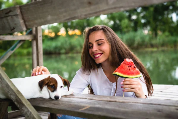 Kvinna med sitt husdjur på River dock äta vattenmelon — Stockfoto