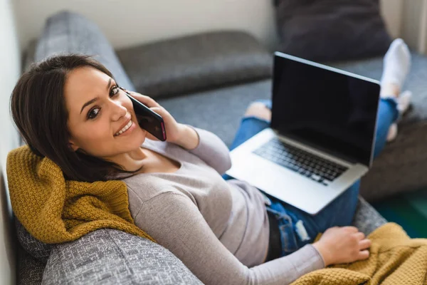 Hübsche Frau Spricht Smartphone Und Arbeitet Hause Mit Laptop — Stockfoto