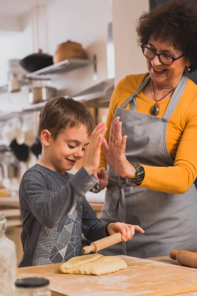 grandson and grandmother cooking together in home kitchen