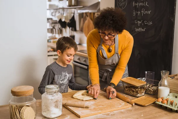 grandson and grandmother cooking together in home kitchen