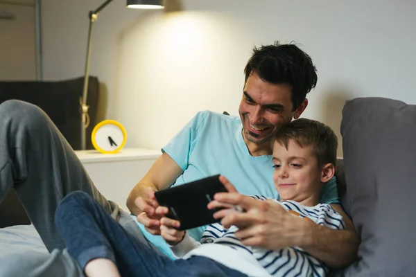 Ojciec i syn grając w gry na tablecie w domu — Zdjęcie stockowe