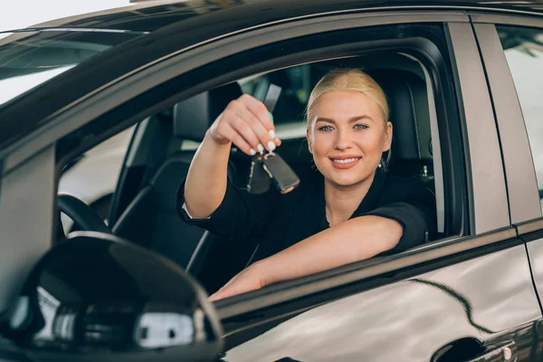 Woman Sitting New Car Holding Keys Car Dealership Showroom — Stock Photo, Image