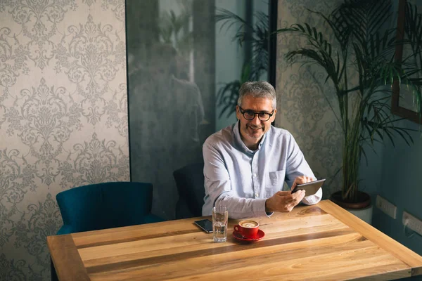 Średnim Wieku Człowiek Pomocą Tabletu Picia Kawy Restauracji — Zdjęcie stockowe