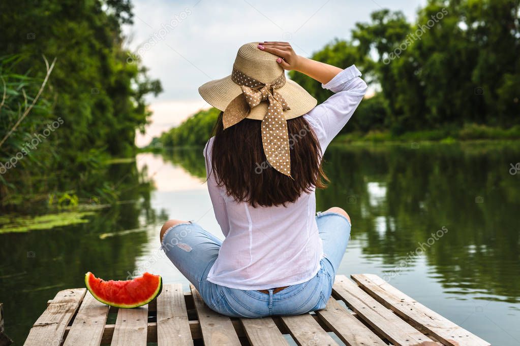 woman sitting on river dock