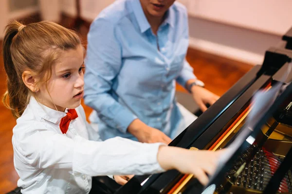 在教授的帮助下弹钢琴的小女孩 — 图库照片