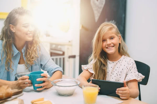 Niña Rubia Usando Tableta Mientras Desayuna Con Madre Casa — Foto de Stock