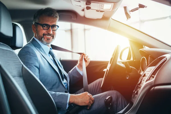 İş adamı emniyet kemerini takıyor.