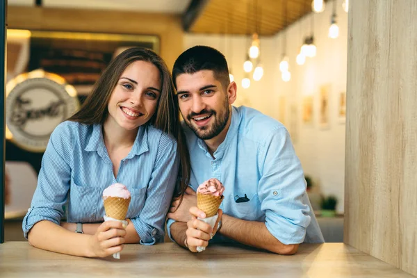 Szczęśliwa para jedząca lody w cukierni — Zdjęcie stockowe