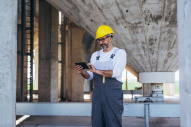 İnşaat işçisi olay yerinde tablet kullanıyor
