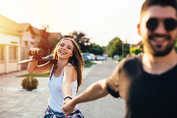 Vacker glad ung par körning skateboard utomhus — Stockfoto