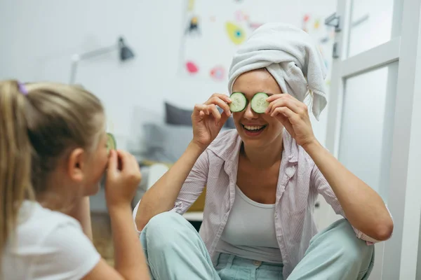 Mutlu aile zamanları, evde cilt bakımı yapan anne ve kız..