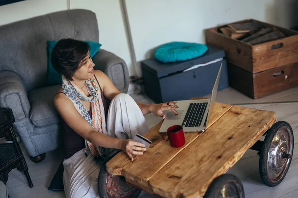 Mulher navegando on-line em seu laptop em sua casa — Fotografia de Stock