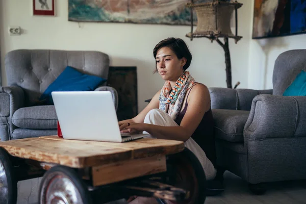 Donna navigando online sul suo computer portatile a casa sua — Foto Stock