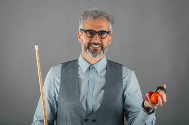 Stüdyoda bilardo oyuncusunun sopası ve topları vardı.