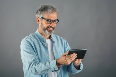 İzole edilmiş tablet kullanan orta yaşlı bir adam