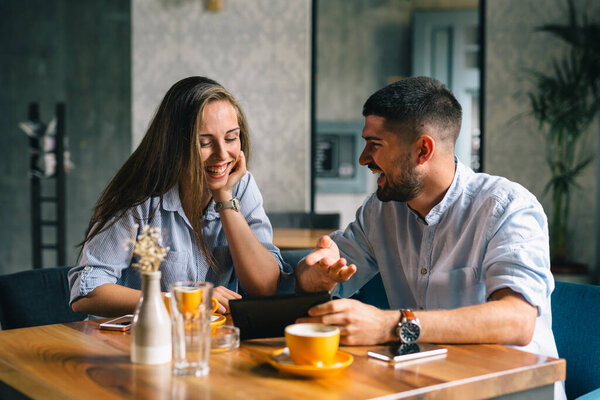 friends ordering food using tablet in restaurant