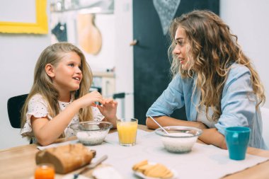 Anne ve kızı evde kahvaltı yapıyor.