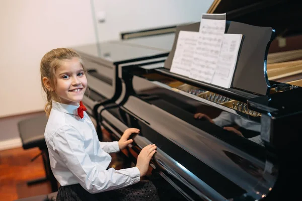 happy little girl teaching to play piano