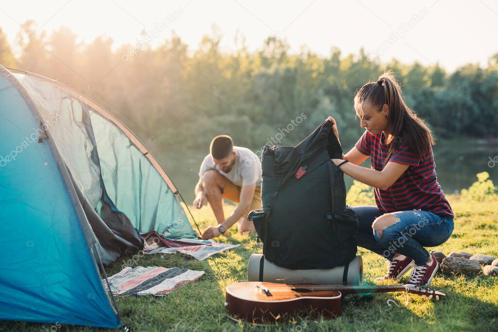 friends on camping. preparing camping tent