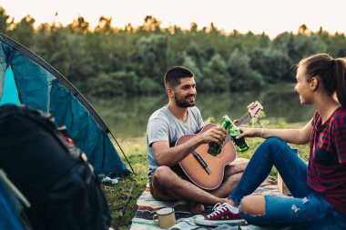 Romantik çift göl kenarında birlikte kamp yapıyor.