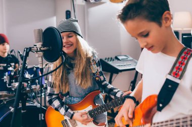 Çocuklar rock grubu müzik stüdyosunda çalıyor.
