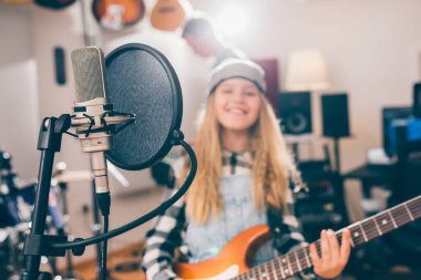 Stüdyo mikrofonunu kapat ve arka planda gitar çalan bulanık çocuk