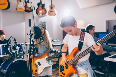 Çocuklar rock grubu müzik stüdyosunda çalıyor.