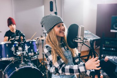 Kız müzik stüdyosunda şarkı söylüyor.