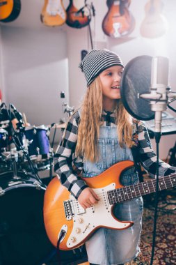 Gitar çalan ve şarkı söyleyen bir kız.
