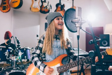 Gitar çalan ve şarkı söyleyen bir kız.