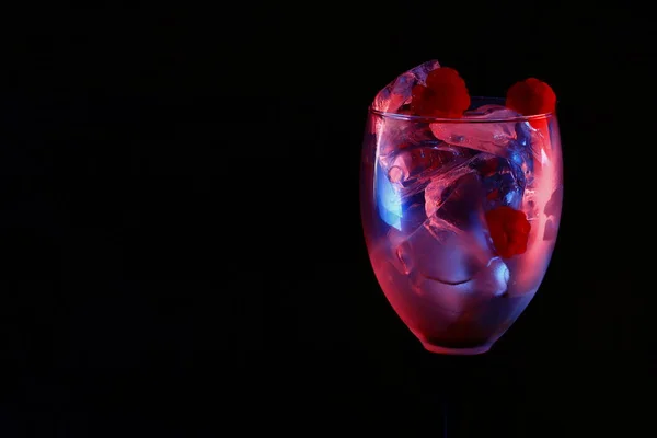 Güzel kristal terli cam buz ve meyveler siyah bir arka plan üzerinde kırmızı ve mavi ışık yanan gibi görünüyor!