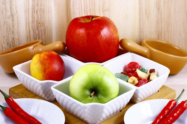 Taze meyve ve sebze seramik bir kare tencerede bir mutfak tahtada natürmort.