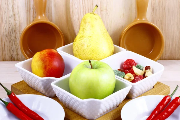 Taze meyve ve sebze seramik bir kare tencerede bir mutfak tahtada natürmort.