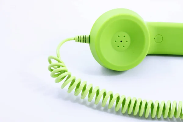 Beyaz bir arka planda retro yeşil tüp ile telefon.