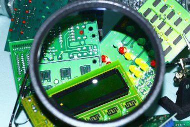 Elektronik bileşenleri devre kartlarına Büyüteç ön planda ile basılmış.