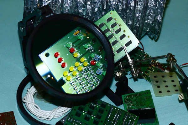 Elektronik bileşenleri devre kartlarına Büyüteç ön planda ile basılmış.