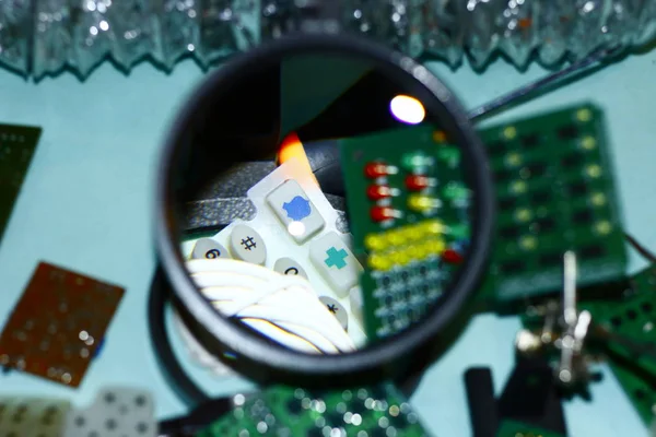 Elektronik bileşenleri devre kartlarına Büyüteç ön planda ile basılmış.